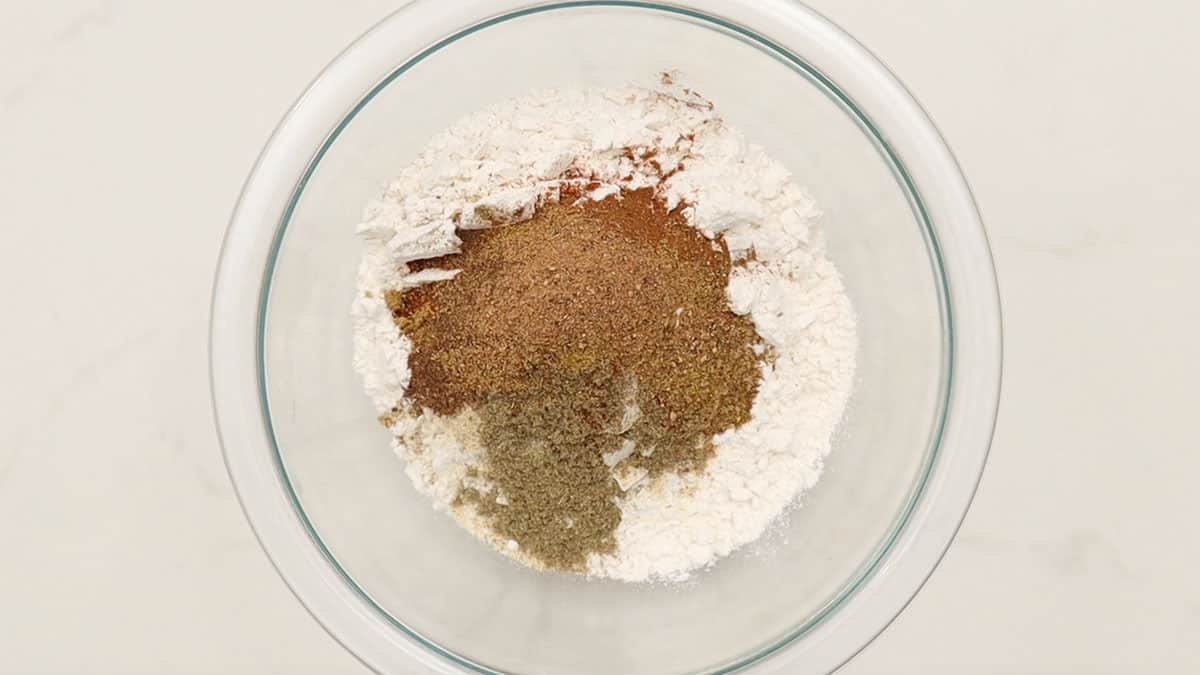 overhead of a mixing bowl with flour and spices