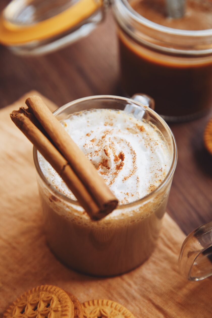 side view of a pumpkin spice latte with a cinnamon stick as garnish