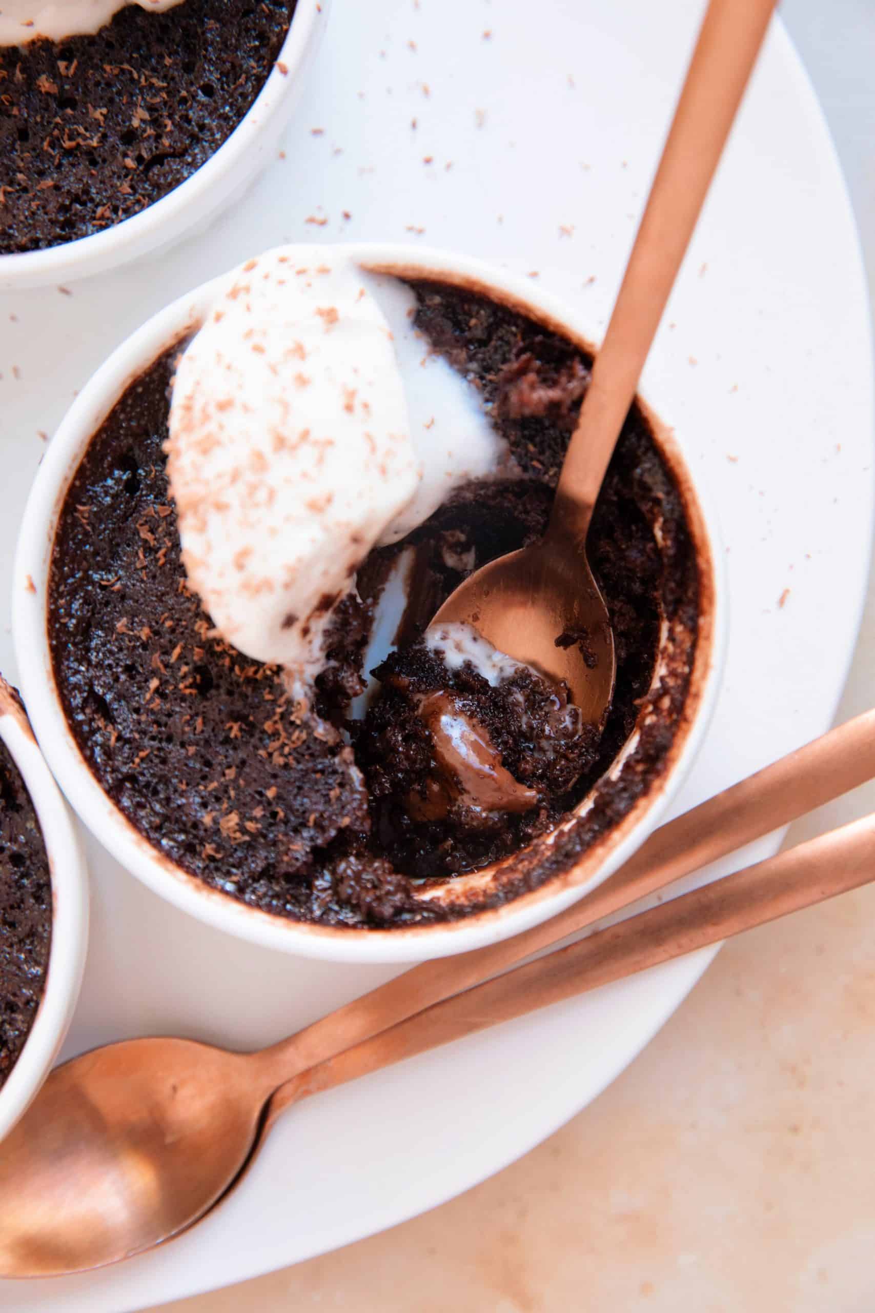 close up of molten chocolate cakes with a spoon revealing the gooey insides