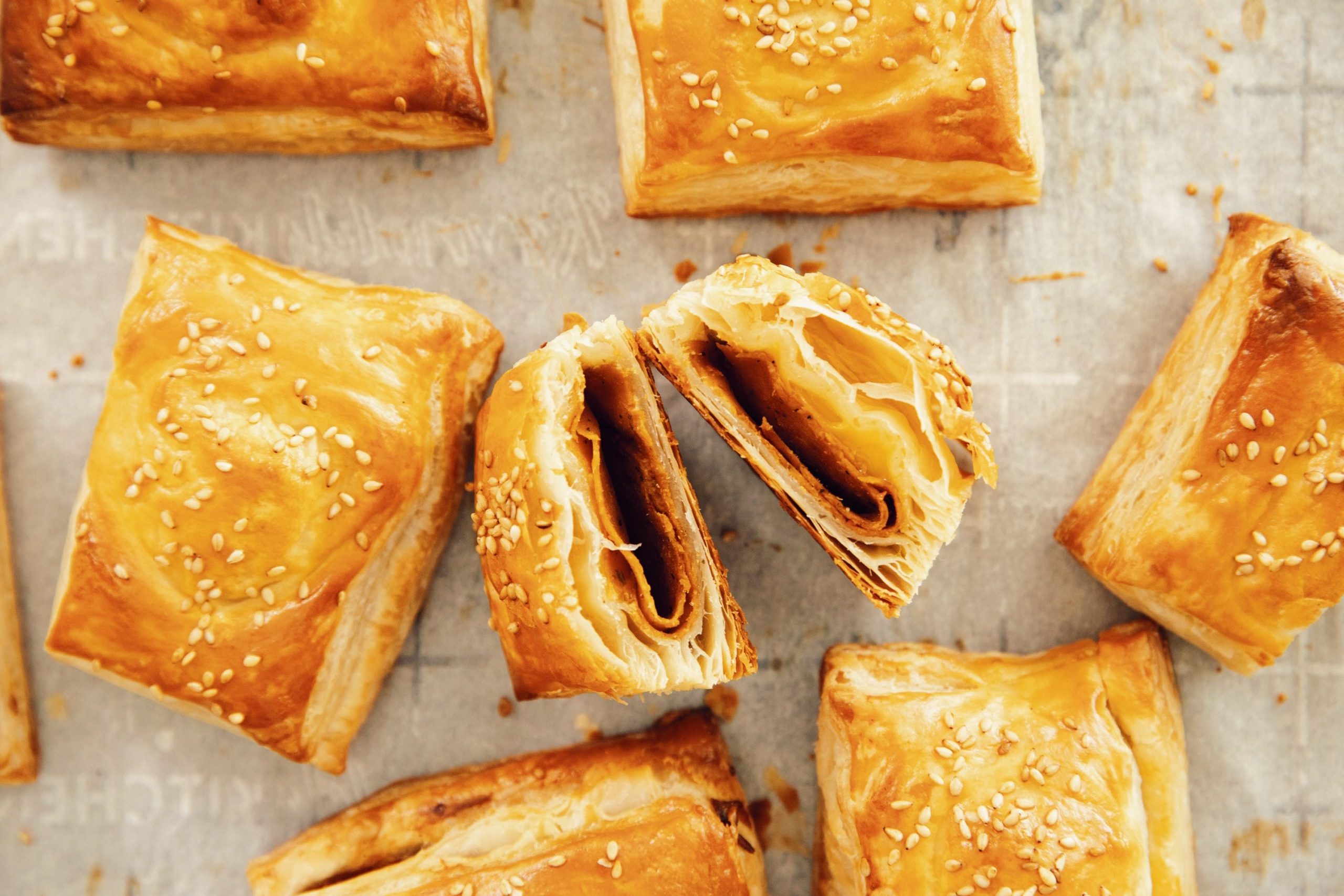 overhead with vegan ham and cheese croissants on a baking sheet with one open showing the inside