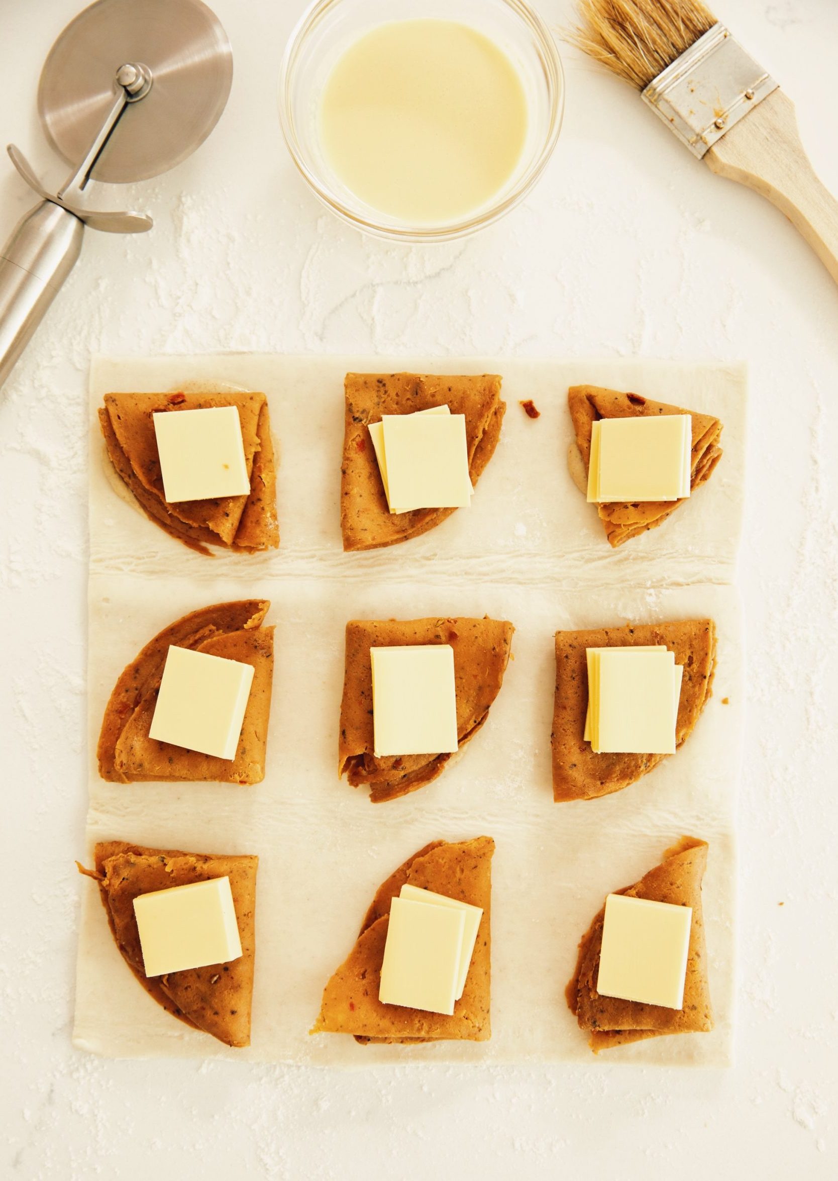 overhead of vegan ham and cheese croissants being assembled with puff pastry